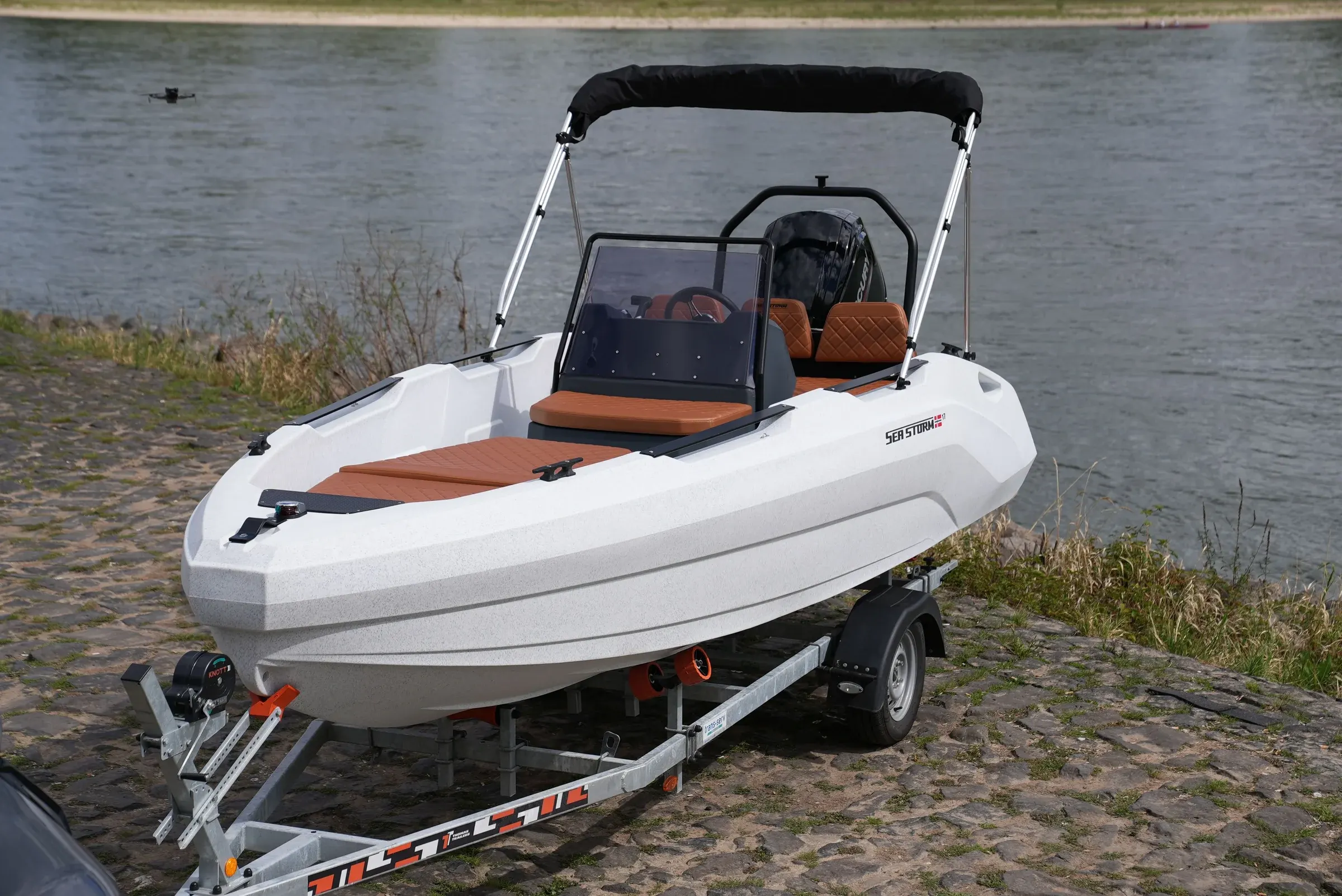 SeaStorm 17 in white with brown cushions and bimini, view from the front at an angle