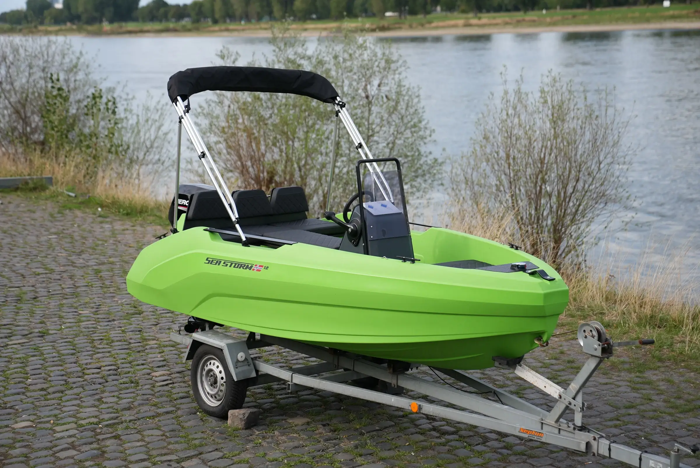 SeaStorm 12 in Lime Green with bimini cover on the trailer, view from the front at an angle